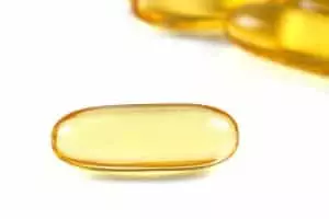 Close up of a cod liver fish oil capsule a nutritional supplement high in omega-3 fatty acids EPA DHA.